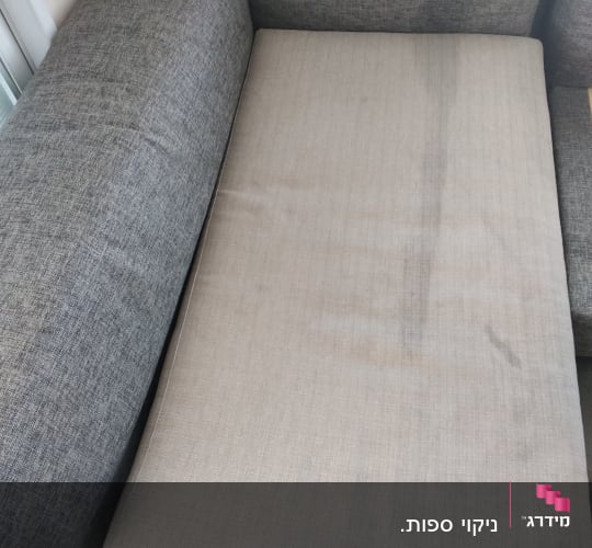 ספה אפורה עם כתמים על המושב
